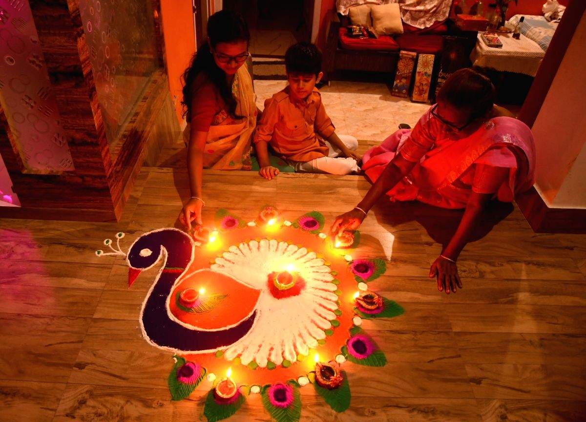 Women decorate a rangoli