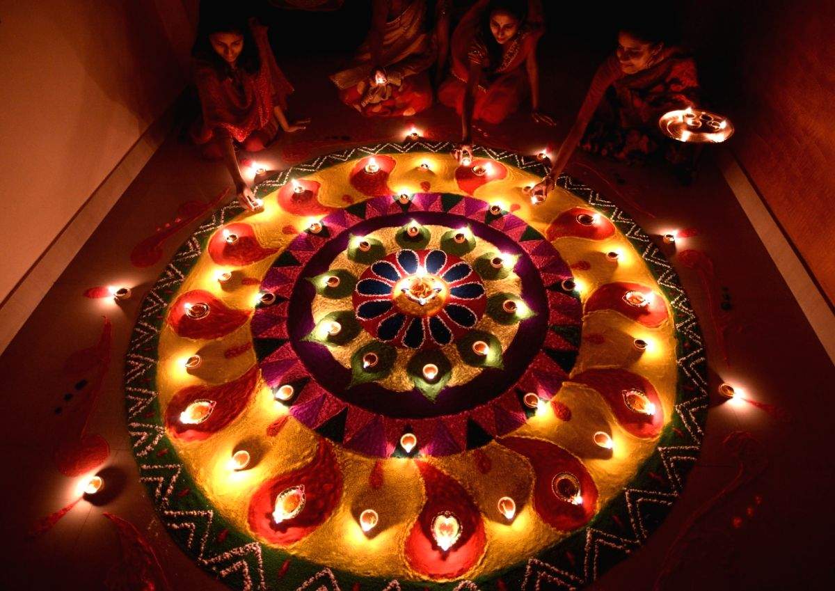 Women light earthen lamps on Diwali